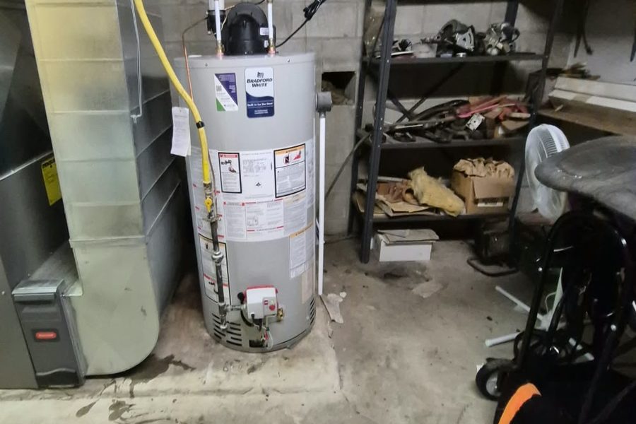 Bradford White power-vent water heater installed beside a furnace