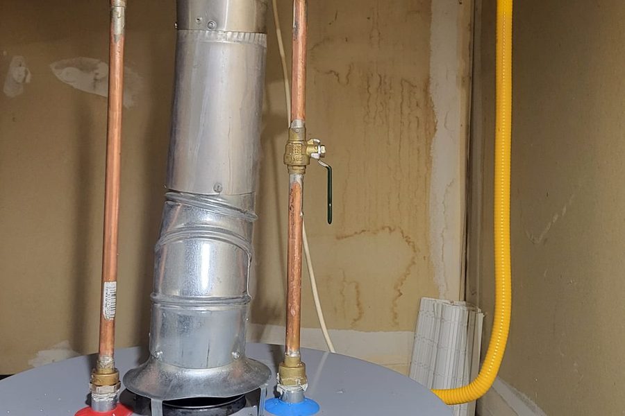 Top of a water heater with draft hood and connections