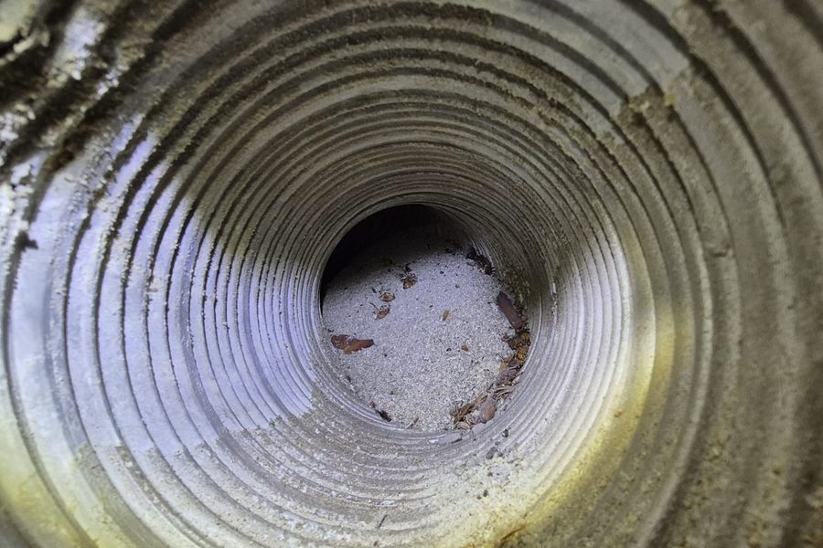 Inside a water heater flue pipe: corrosion, scale and debris partially blocking the vent